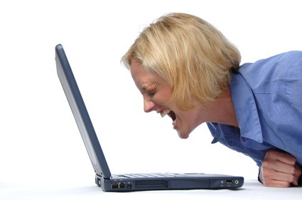 Businesswoman screaming at her lap top